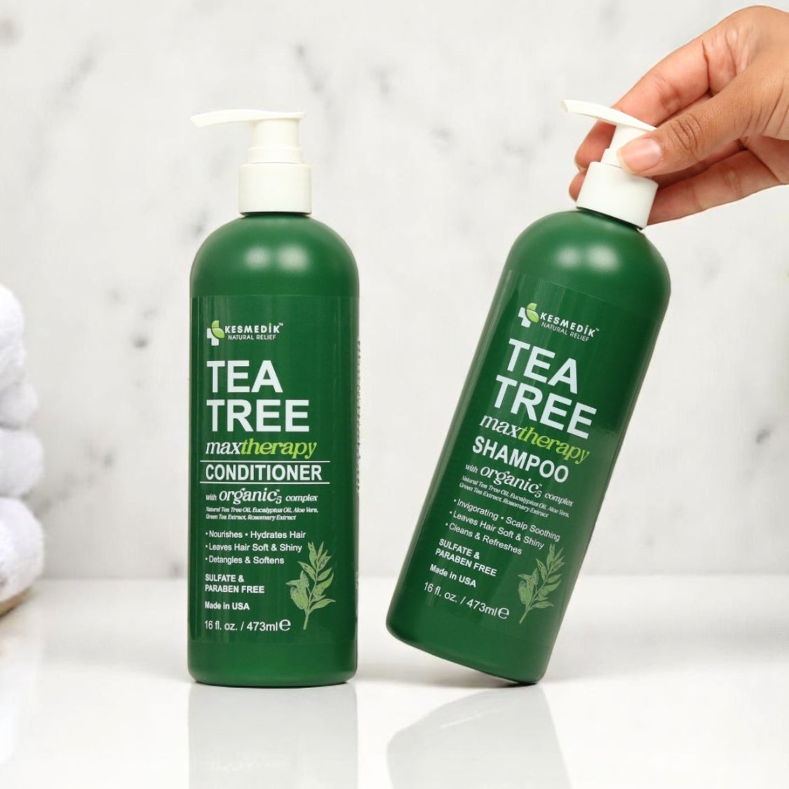 Kesmedik tea tree shampoo and conditioner pump bottles on a bathroom counter.